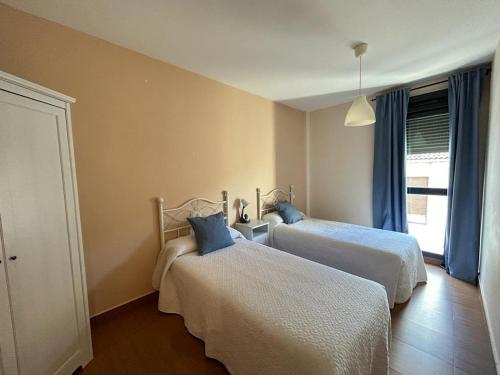 a bedroom with two beds and a window at Ronda Navarra by Valdesierra in Béjar