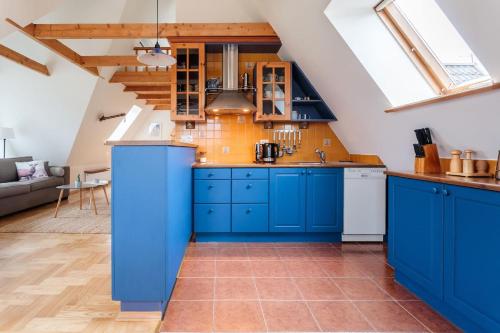 ザコパネにあるRent like home - Oberconiówkaの青いキャビネットとオレンジのタイルが備わるキッチン