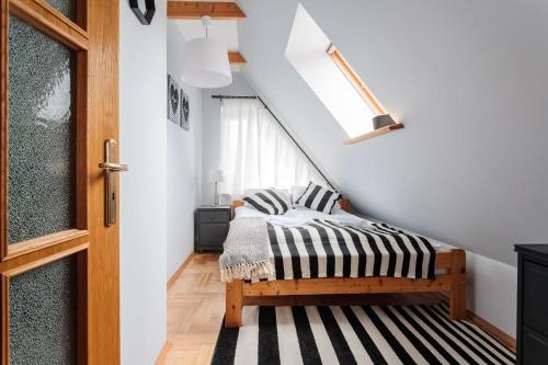 ザコパネにあるRent like home - Oberconiówkaのベッドルーム1室(ベッド1台付)、階段(窓付)が備わります。