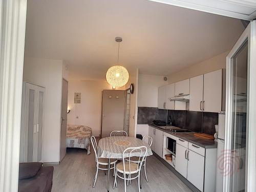 une cuisine et une salle à manger avec une table et des chaises dans l'établissement Studio rénové avec balcon à 650m des Thermes - Lamalou, proche centre-ville et nature - FR-1-451-96, à Lamalou-les-Bains