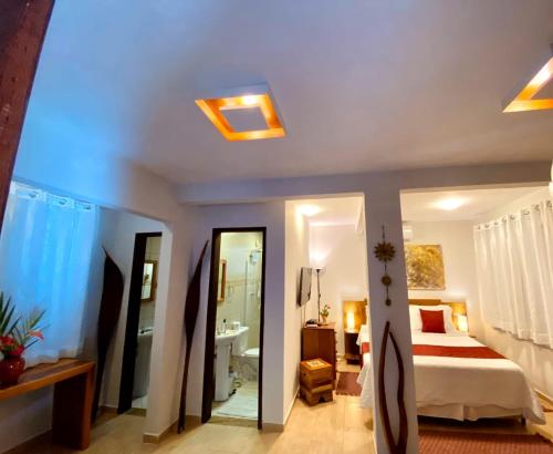 a bedroom with a bed and a bathroom with a mirror at Espaço Viverde Penedo in Penedo