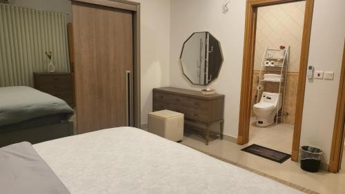 a bedroom with a bed and a mirror and a television at شقة متكاملة VIP غرفتين وجلسة خارجية in Riyadh