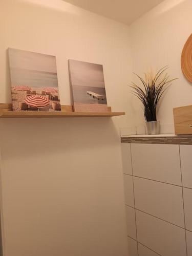 a shelf with two pictures on top of a wall at Grand studio avec balcon en bord de mer in Palavas-les-Flots