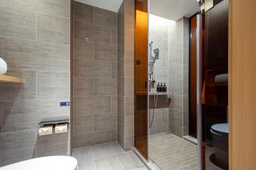 a bathroom with a shower and a toilet at Atour Hotel Meizhou West Station R&F Center in Meizhou