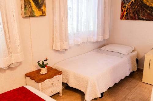 a bedroom with two beds and a window at Espaço Viverde Penedo in Penedo
