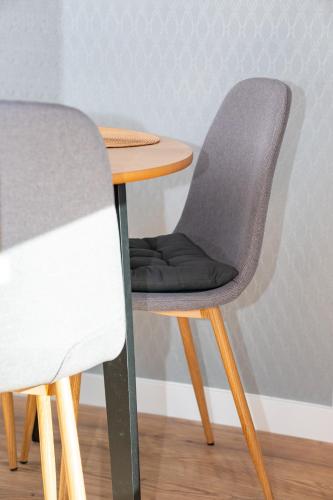 a table with a gray chair next to a wooden table at GO Jahorina by Olympic Gardens in Jahorina