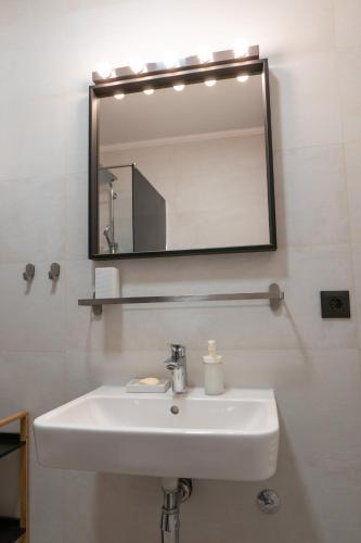 a bathroom with a white sink and a mirror at GO Jahorina by Olympic Gardens in Jahorina