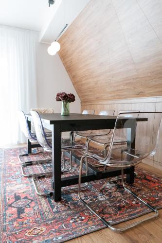 a dining room with a table and chairs on a rug at GO Jahorina by Olympic Gardens in Jahorina