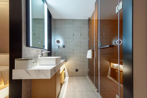 a bathroom with a sink and a shower at Atour Hotel Meizhou West Station R&F Center in Meizhou