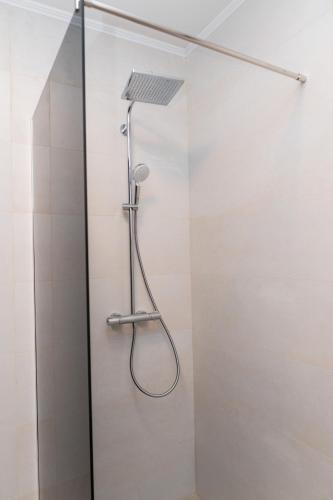 a shower with a shower head in a bathroom at GO Jahorina by Olympic Gardens in Jahorina