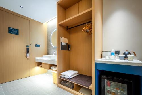 a bathroom with a sink and a fireplace at Atour Hotel Meizhou West Station R&F Center in Meizhou