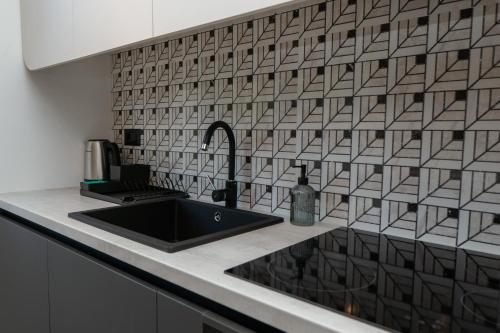 a kitchen with a black sink and a tile wall at GO Jahorina by Olympic Gardens in Jahorina
