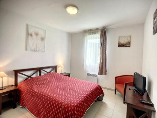 - une chambre avec un lit rouge et une télévision dans l'établissement Appartement F2 climatisé avec terrasse, proche centre-ville et thermes, animaux acceptés - FR-1-451-117, à Lamalou-les-Bains