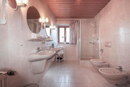 un bagno con due lavandini e una doccia e due servizi igienici di Ferienwohnungen Beim Zellerbäck a Ruhpolding