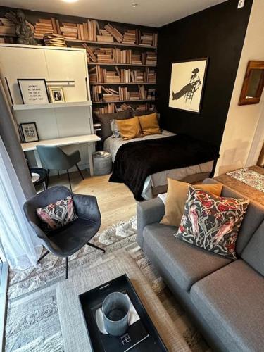 uma sala de estar com um sofá e um piano em Stunning studio with ocean view em Kristiansand