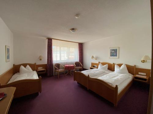 a hotel room with two beds and a table at Hotel-Restaurant Zum Loewen in Jestetten