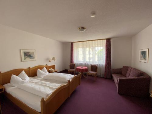 um quarto de hotel com uma cama grande e uma cadeira em Hotel-Restaurant Zum Loewen em Jestetten