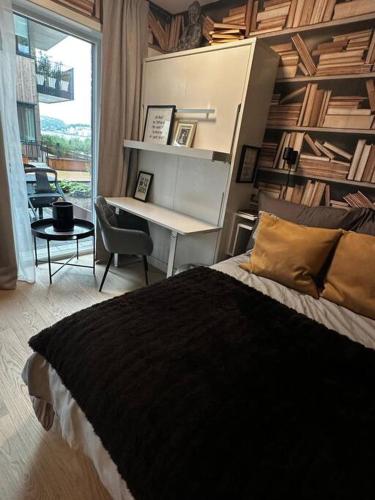 um quarto com uma cama, uma secretária e uma mesa em Stunning studio with ocean view em Kristiansand