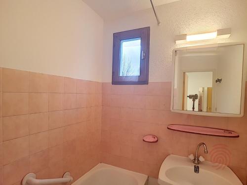 une salle de bain avec un lavabo et un miroir dans l'établissement Appartement F2 avec Terrasse, Wifi et Proximité Thermes à Lamalou-les-Bains - FR-1-451-118, à Lamalou-les-Bains