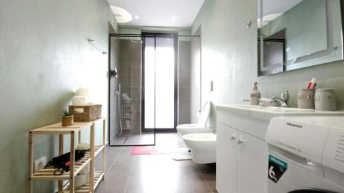 een badkamer met een douche, een toilet en een wastafel bij 999 Apartments in Tirana