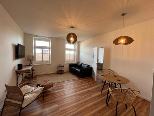 a living room with a black couch and a table at Apartmány Malé náměstí, Broumov in Broumov