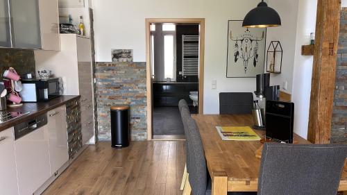 a kitchen and dining room with a wooden table at Stadthaus Artur - Apartment Valencia in Remscheid