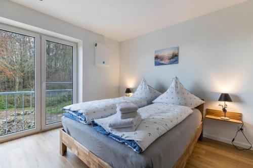 een slaapkamer met een bed en een groot raam bij Hodderup Wohnung 10 in Husby
