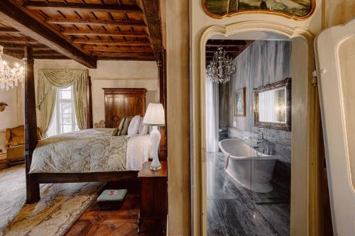 a bedroom with a bed and a bath tub and a sink at Castello di Casalborgone, Luxury Italian Castle Hotel in Casalborgone