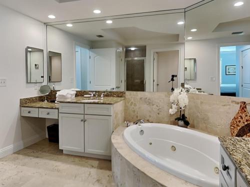 La grande salle de bains est pourvue d'une baignoire et d'un grand miroir. dans l'établissement Indigo West #402, à Perdido Key