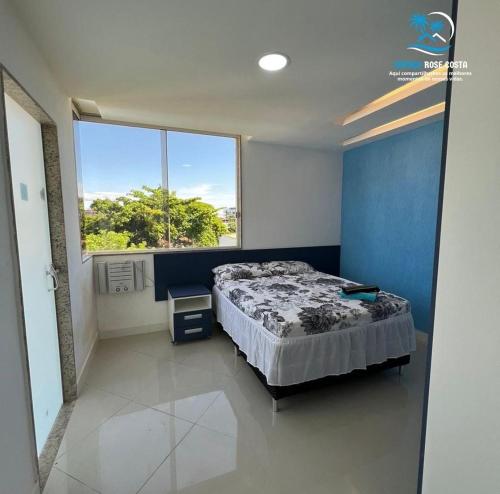 ein Schlafzimmer mit einem Bett und einem großen Fenster in der Unterkunft Espaço Rose Costa in Niterói