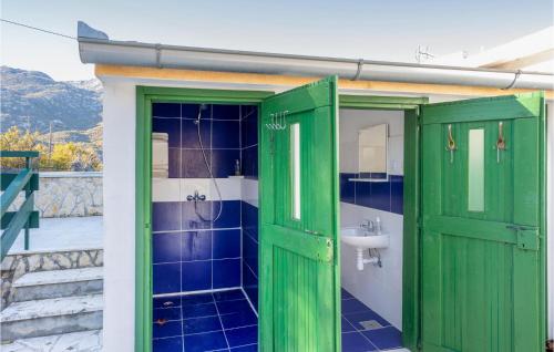 a bathroom with green doors and a sink at Awesome Home In Dugopolje With Outdoor Swimming Pool in Dugopolje