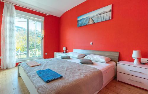 a bedroom with a red wall with a large bed at Awesome Home In Dugopolje With Outdoor Swimming Pool in Dugopolje