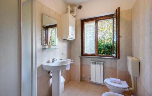 een badkamer met een wastafel, een toilet en een raam bij Valguerriera - Grano in Apecchio