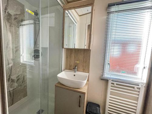 La salle de bains est pourvue d'un lavabo et d'une douche. dans l'établissement Beautiful Caravan At Manor Park Nearby Hunstanton Beach Ref 23030w, à Hunstanton