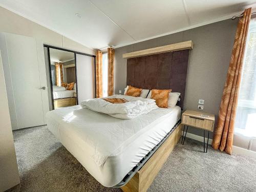 ein Schlafzimmer mit einem großen Bett und einem Fenster in der Unterkunft Stunning Lodge With Decking Nearby Hunstanton Beach, Sleeps 6 Ref 23215k in Hunstanton