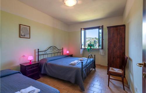 een slaapkamer met 2 bedden, een raam en een stoel bij Valguerriera 4 - Casale in Apecchio