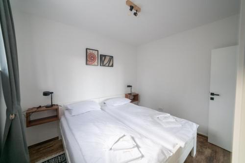 a bedroom with a bed with white sheets at Kuca 59 in Jahorina
