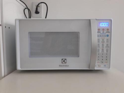 a microwave oven sitting on top of a counter at Suíte Privativa em Casa de Vila in Rio de Janeiro