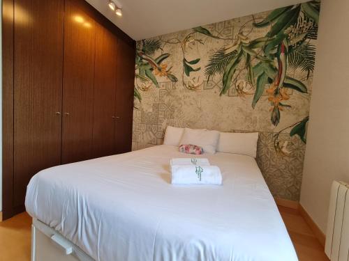 sypialnia z dużym białym łóżkiem i tapetą w kwiaty w obiekcie Ático de Lujo en el Centro de Burgos w mieście Burgos