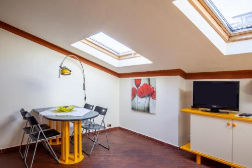 a dining room with a table and a tv at Loft parallela lungomare posto auto in Viareggio