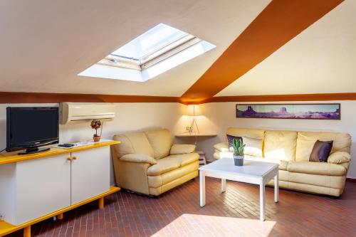 a living room with a couch and a tv at Loft parallela lungomare posto auto in Viareggio