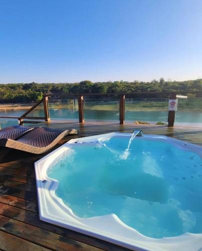 bañera de hidromasaje en una terraza con vistas al agua en Recanto dos sonhos, en Betim