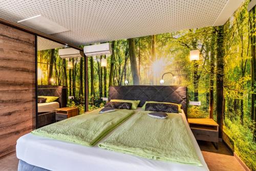 una camera con letto e murale nel bosco di Azuria Schwarzwald Loft a Kappelrodeck