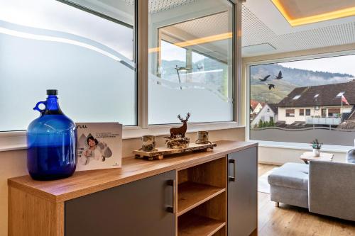 a large blue vase sitting on a table in a room with windows at Azuria Schwarzwald Loft in Kappelrodeck