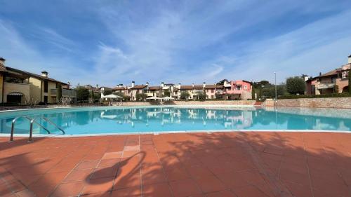 a large swimming pool with blue water and buildings at Poggio al sole in Manerba del Garda