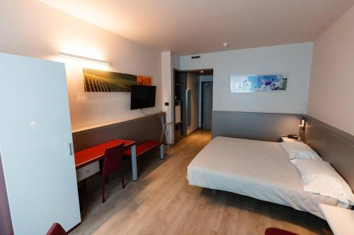 una camera d'albergo con letto e scrivania, un letto e una camera di Hotel Ristorante I Castelli ad Alba