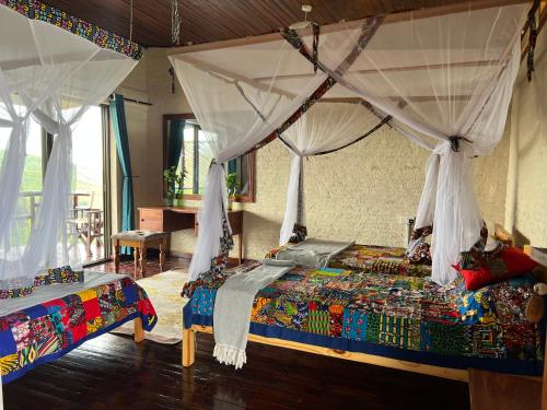 a bedroom with a bed with a canopy at The Coffee Lodge at Clarke Farm in Fort Portal
