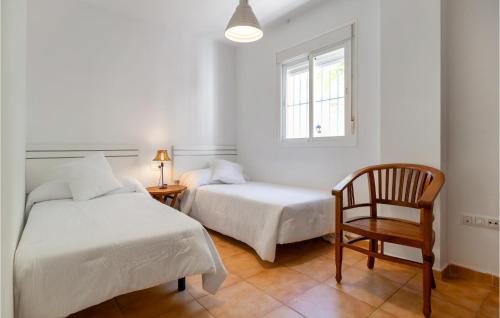 a bedroom with two beds and a chair and a window at Gorgeous Apartment In Sanlcar De Barrameda With Wifi in Sanlúcar de Barrameda