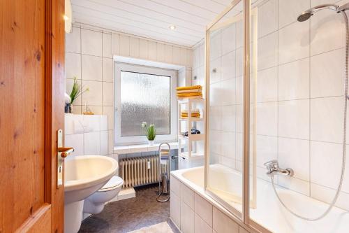 uma casa de banho com uma banheira, um lavatório e um WC. em Ferienwohnung Busch em Meinerzhagen