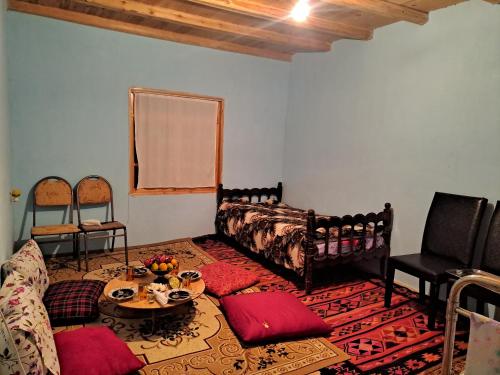 a living room with a couch and a table at Xinaliq İzzet's Riverside Home Stay in Xınalıq